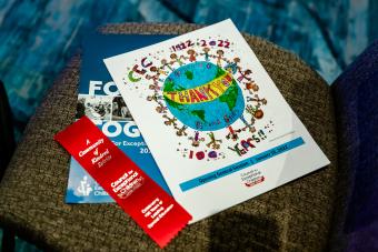 Printed copies of the 100th Anniversary pamphlet, ribbon, and new Strategic Plan on a chair at the CEC 2022 Convention & Expo in Orlando