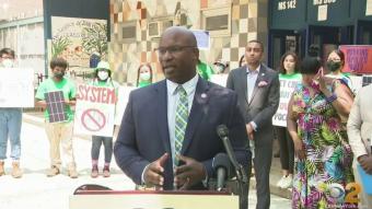 Rep. Bowman speaking with rally behind him