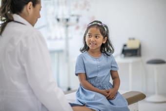 [image of a child sitting with a school nurse]