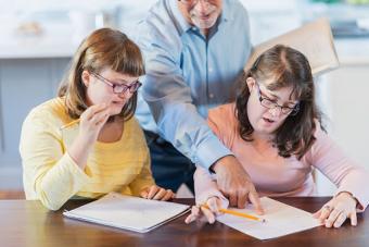 Professor working with two students with disabilities in university setting